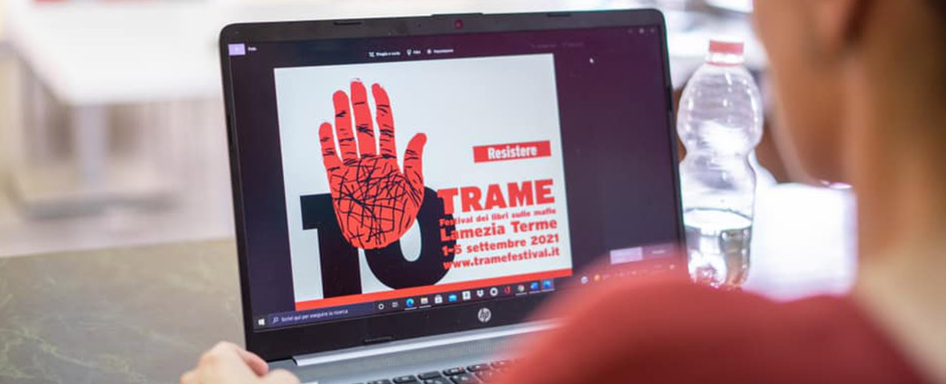 Una donna guarda al pc la locandina del Trame festival 2021