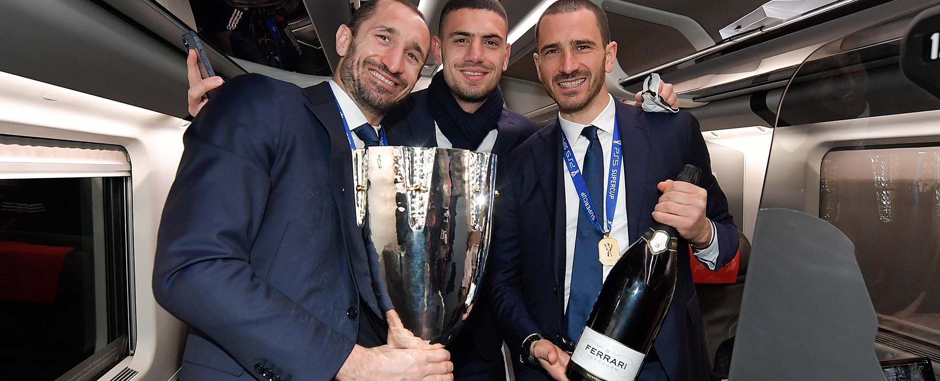 I calciatori della Juventus Giorgio Chiellini, Merih Demiral e Leonardo Bonucci in viaggio sul Frecciarossa verso Torino con la Supercoppa Italiana tra le mani