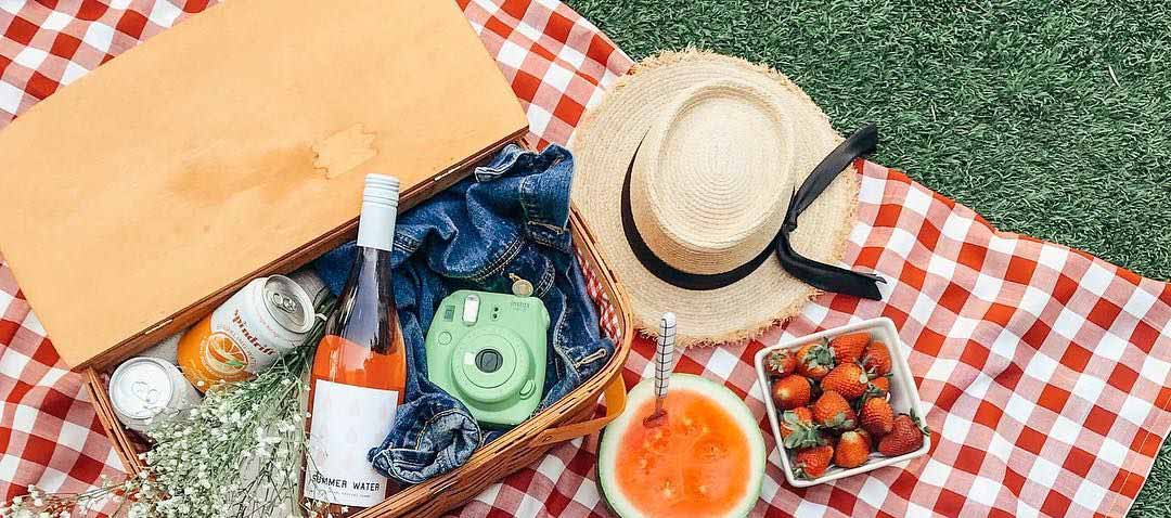 Una tovaglia a quadri e cesti pieni di cibo per il più classico dei picnic