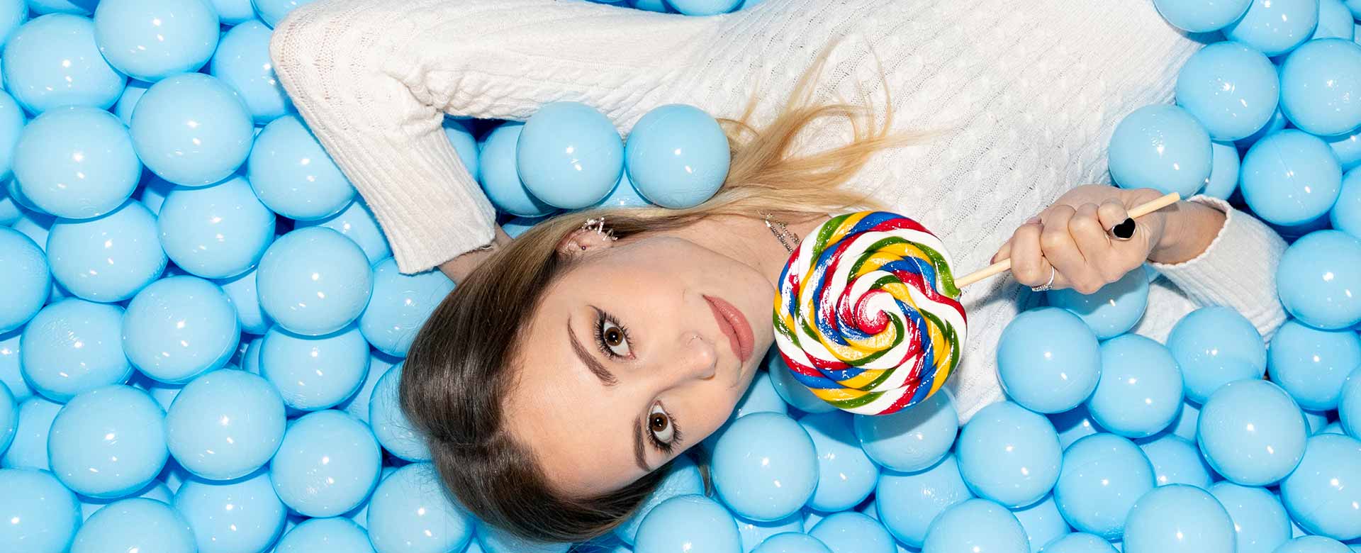 Immagine di una ragazza in una vasca di palline azzurre