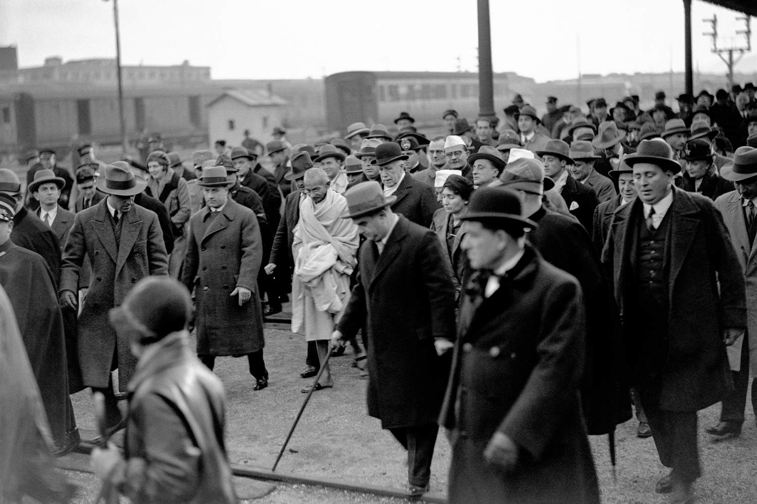 Gandhi, seguito da una folla di persone, attraversa la stazione Termini al suo arrivo a Roma