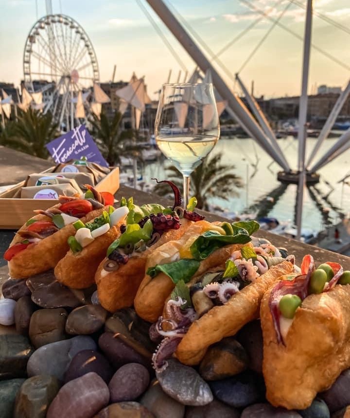 Cibo, bicchiere di vino e mare di Genova