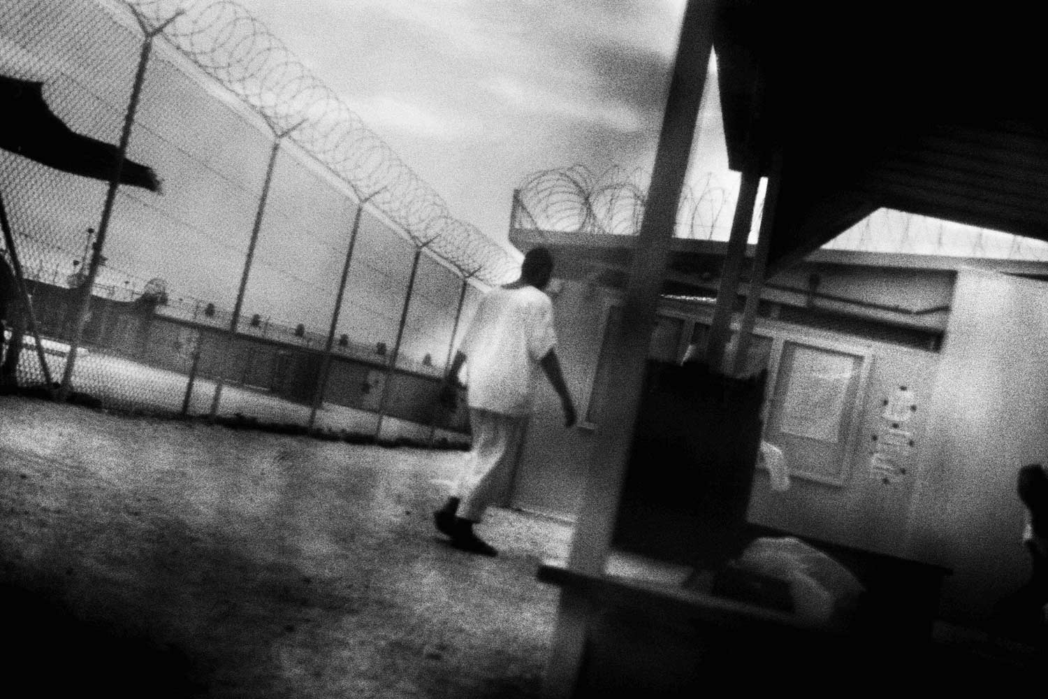 Detenuti attraversano il campo 4 nel centro di detenzione di Guantánamo. Guantánamo, Cuba (2006)