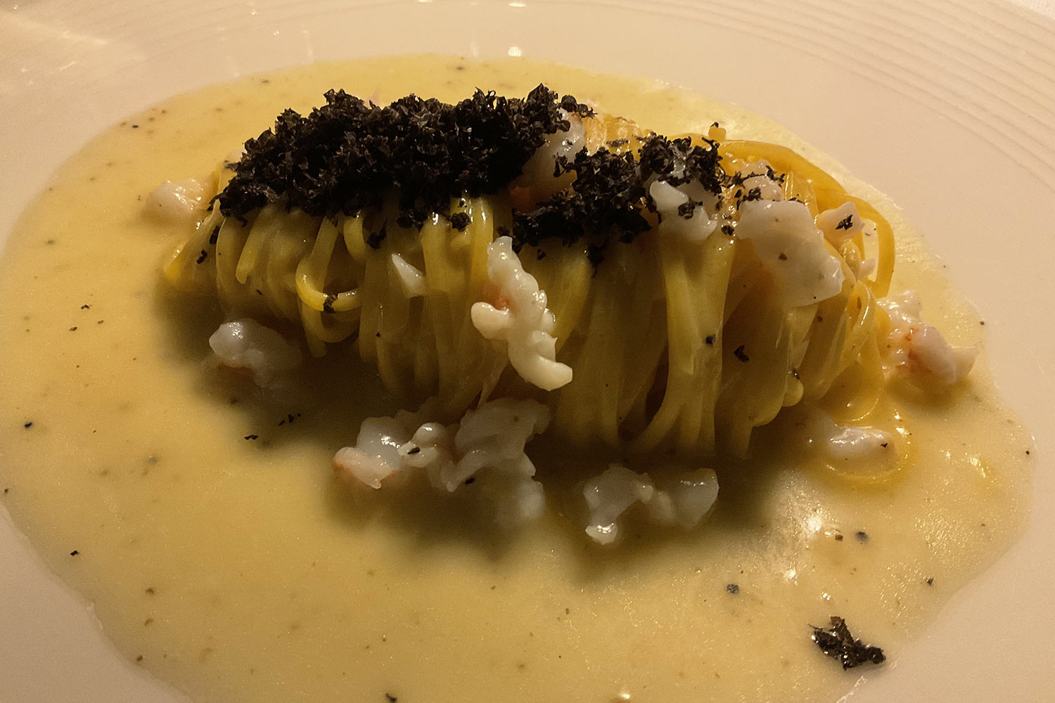 Tagliolino al burro di Normandia con scampi e tartufo nero, un piatto del ristorante Corrallium di Milano