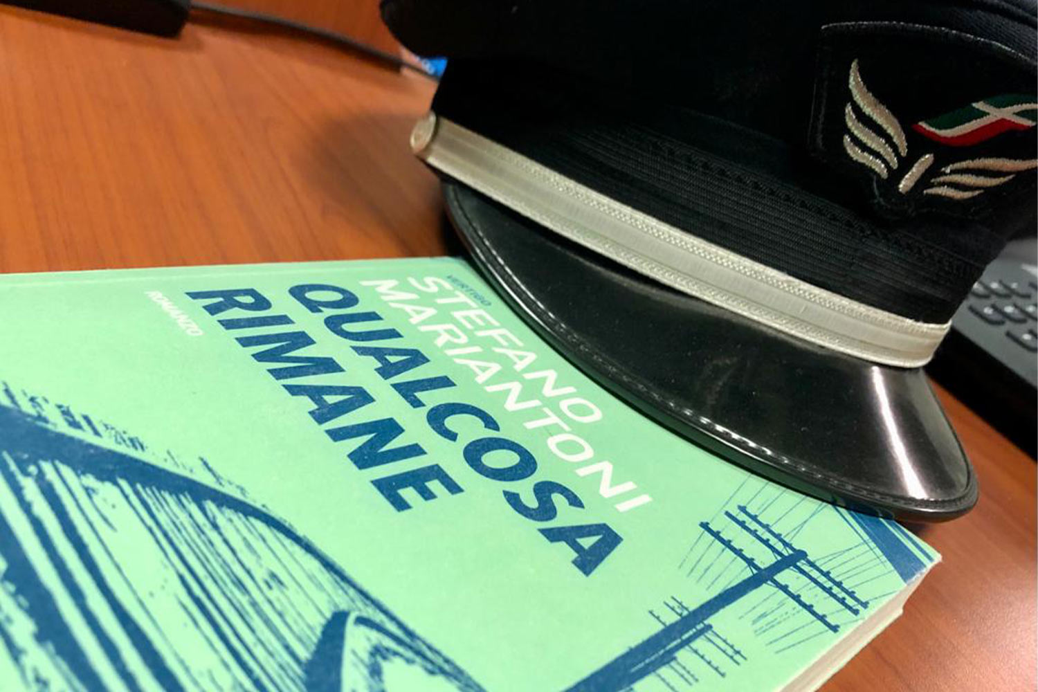 Il libro Qualcosa rimane di Stefano Mariantoni e un cappello da ferroviere
