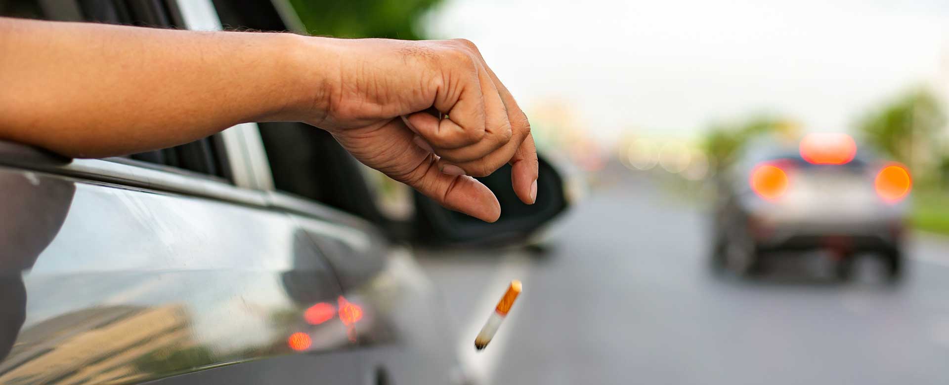Automobilista getta sigaretta dall'auto