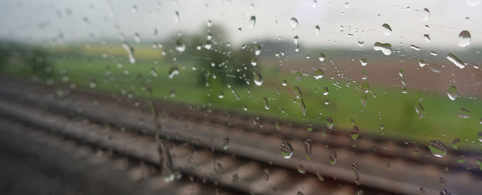 Binari visti da un finestrino bagnato per pioggia