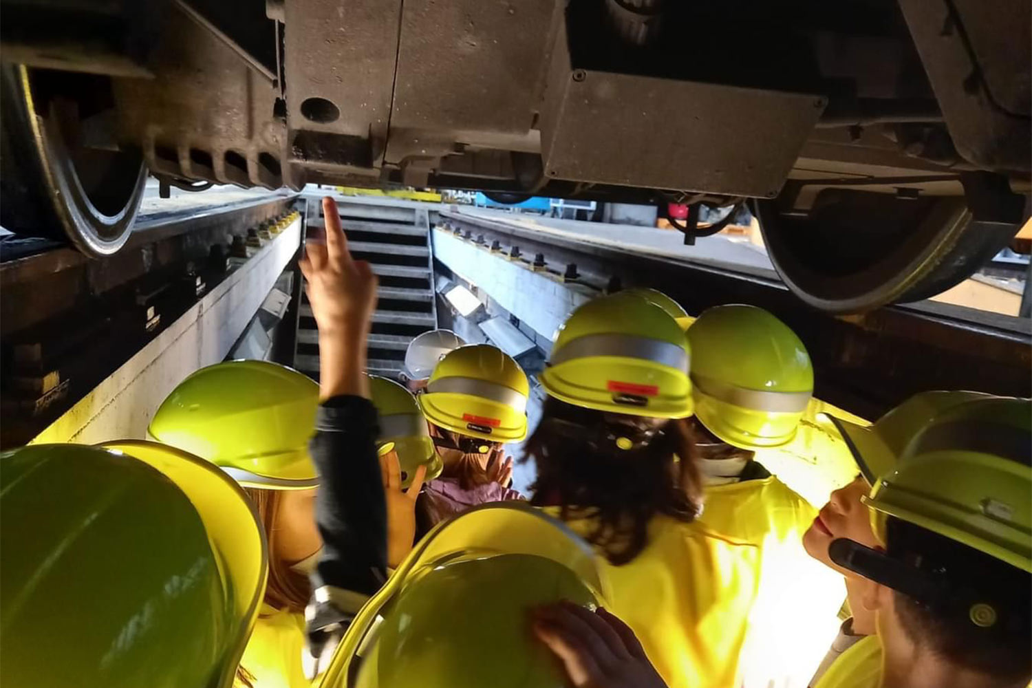 Studenti osservano il sottocassa di un treno