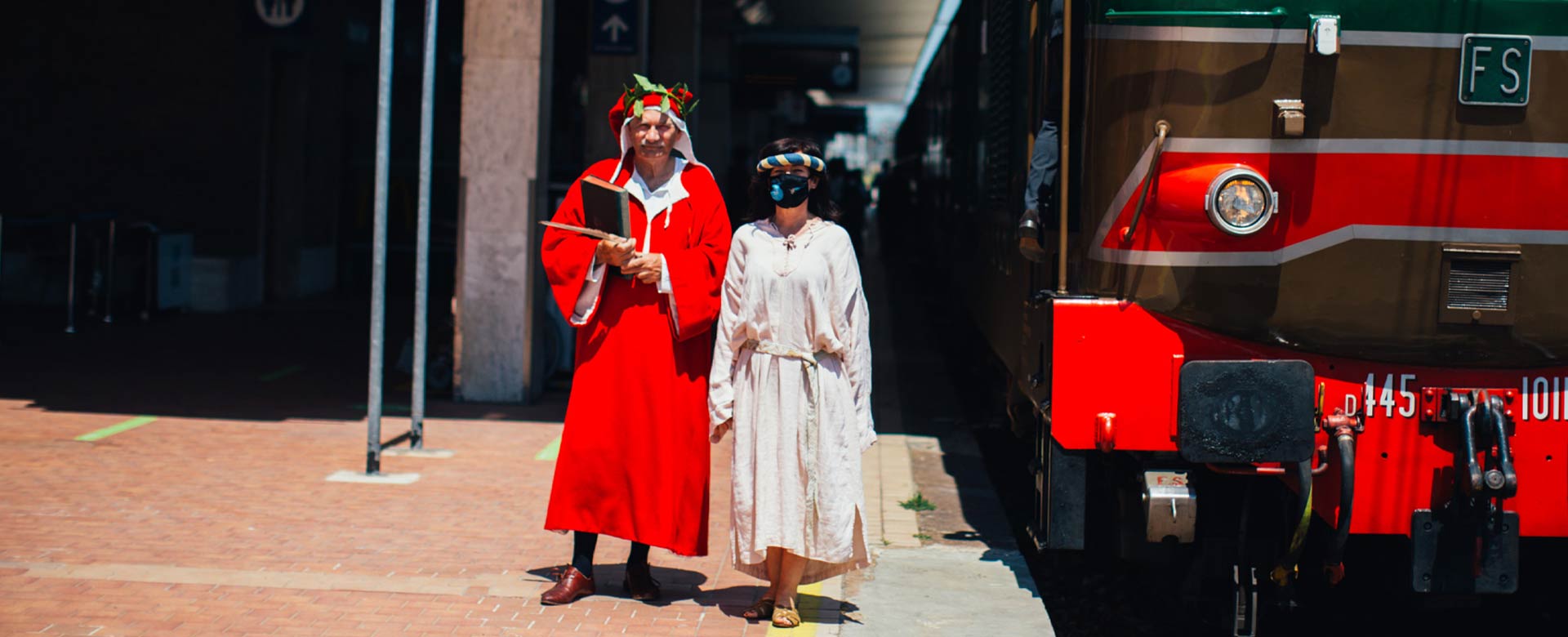 Due figuranti interpretano Dante Alighieri e Beatrice al fianco del Treno di Dante attestato nella stazione ferroviaria di Ravenna © Il Treno di Dante s.r.l.